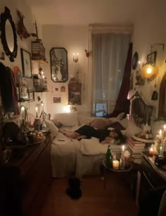 a living room filled with lots of furniture and candles on the floor next to a window