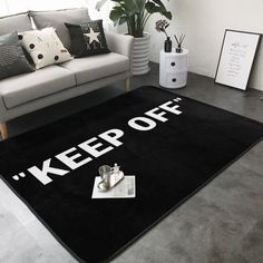 a black rug with the words'keep off'on it in front of a couch