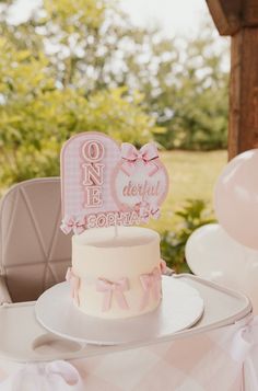 a pink and white cake sitting on top of a table