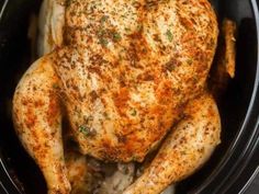 a close up of a chicken in a crock pot with seasoning on it