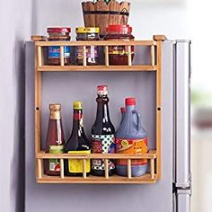 a wooden shelf filled with bottles and condiments next to a refrigerator freezer