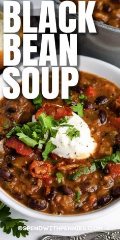 a white bowl filled with black bean soup and topped with sour cream