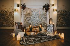 a room filled with candles and pictures on the wall next to a rug covered in fur