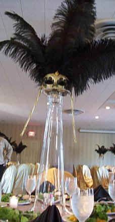 an elaborate table setting with black feathers and wine glasses