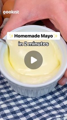 someone is dipping mayo into a bowl with an egg in the background and text that reads homemade mayo in 2 minutes