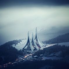 an aerial view of some very tall buildings in the middle of snow covered mountains and trees