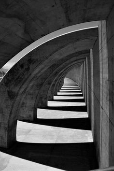 black and white photograph of stairs leading up to the top of a building with concrete walls