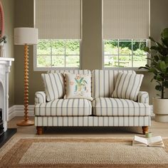 a living room with two couches and a rug in front of the fire place