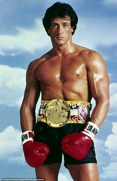 a man with boxing gloves on posing for a photo in front of a cloudy sky