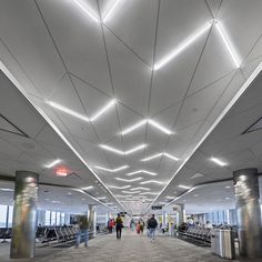 people are walking through an airport with their luggage