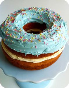 a frosted donut with blue icing and sprinkles on a plate