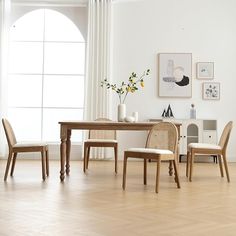 a dining room table and chairs in front of a window