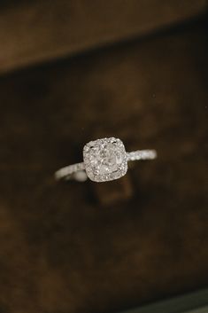 a diamond ring sitting on top of a wooden box