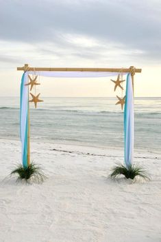 an arch decorated with star decorations on the beach