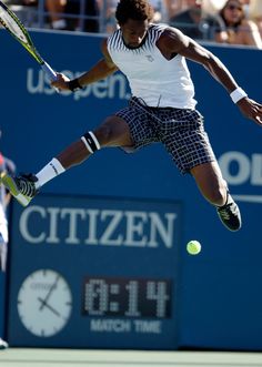 a male tennis player in mid air after hitting the ball with his racquet