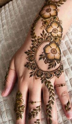 a woman's hand with hennap and flowers on the top of it