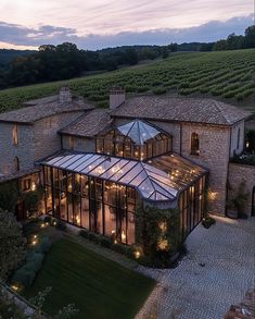 an aerial view of a large house in the middle of a field with lights on it