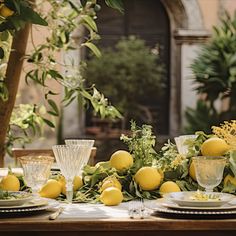 the table is set with lemons and greenery for an elegant dinner or party