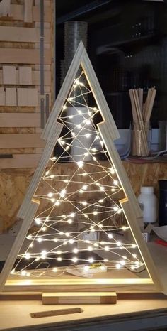 a christmas tree made out of wood with lights on it's sides and the base