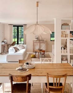 a living room filled with furniture and a wooden table in front of a white couch