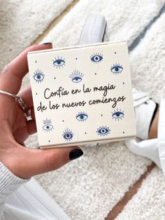 a person holding a box with an evil eye on it in their left hand and the words confia en la maga de las nevoos comergoo compo