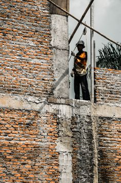 a man standing on top of a brick wall