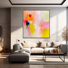 a living room filled with furniture and a large painting on the wall above it's windows