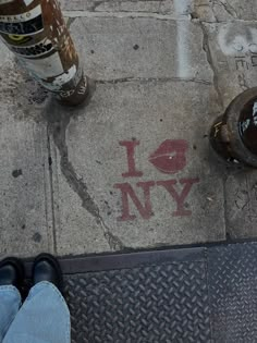 someone is standing on the sidewalk next to a fire hydrant and two beer bottles