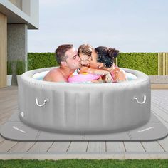 an inflatable hot tub with three people sitting inside and one woman kissing the man's head