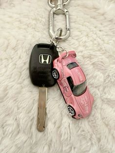 a key chain with a pink car on it and a black key fobl