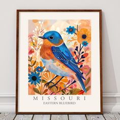 a blue bird sitting on top of a wooden floor next to flowers and plants in a frame