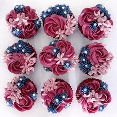 nine cupcakes with pink and blue flowers on them are arranged in a circle