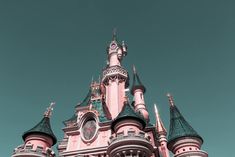 a pink and black castle with two clocks on it's side