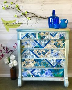 a blue vase sitting on top of a dresser