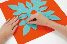 someone is making a paper snowflake decoration