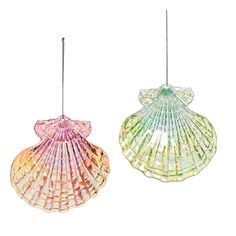 two colorful seashells hanging from strings against a white background