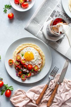 an egg on top of a tortilla with tomatoes