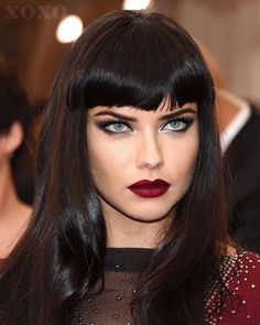 a woman with long black hair and red lipstick