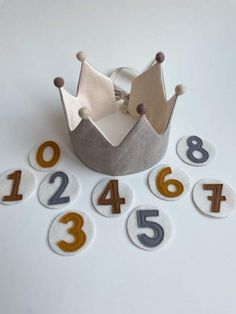 a crown sitting on top of a white table next to numbers and magnets in the shape of numbers