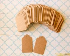 a bunch of brown tags sitting on top of a blue and white table covered in paper