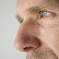 a close up of a man's face with blue eyes