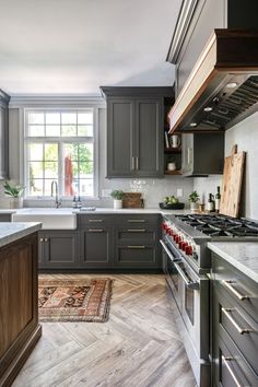 a kitchen with gray cabinets and wooden floors