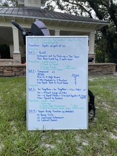 a sign with writing on it sitting in the grass next to a lawn mower