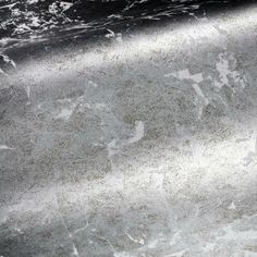 a close up view of the surface of a marbled counter top with white and gray paint