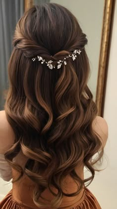 the back of a woman's head with long hair and flowers in her hair