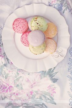 three different colored cookies on a white plate