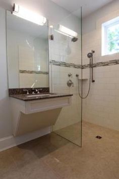 a bathroom with a walk in shower next to a sink and a mirror on the wall