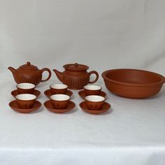 a table topped with lots of brown and white dishes