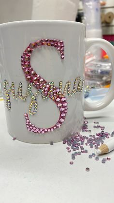 a coffee mug with the word grandma spelled out on it next to some confetti