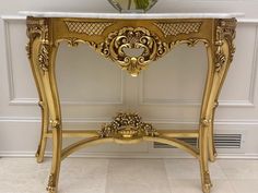 an ornate gold console table with marble top